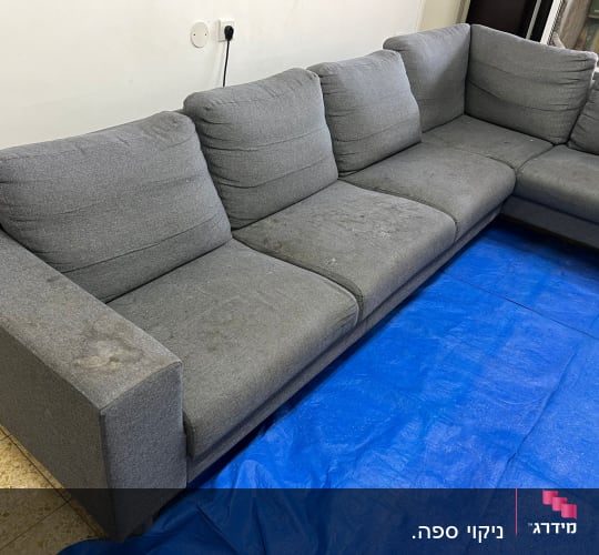 ספה אפורה עם כתמים על יריעת פלסטיק כחולה